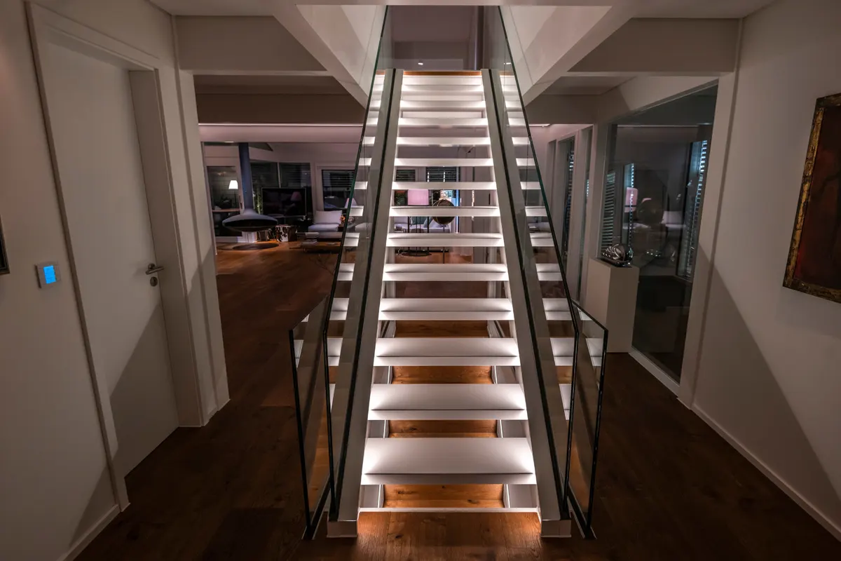 Treppe mit Glasgeländer mit dem Lichtkonzept von Moreno